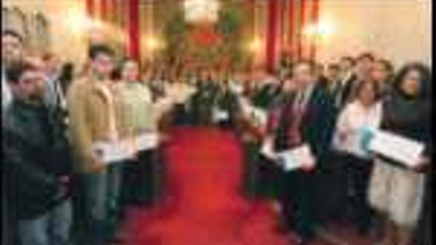 Los premiados, 

rodeando al alcalde, en el Salón Azul del Ayuntamiento