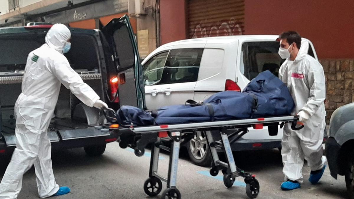 Empleados de la funeraria sacan uno de los cadáveres hallados en un domicilio de Palma.