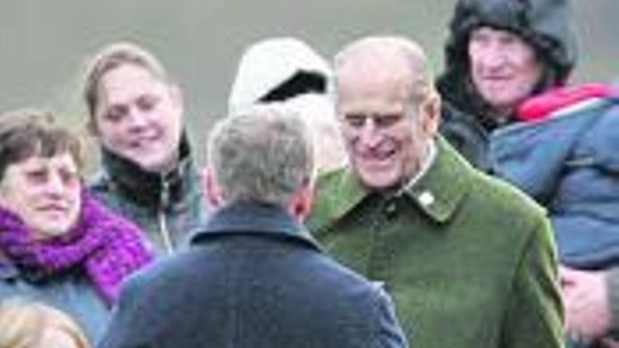 Felipe de Edimburgo, de frente, saluda a un ciudadano antes de misa.