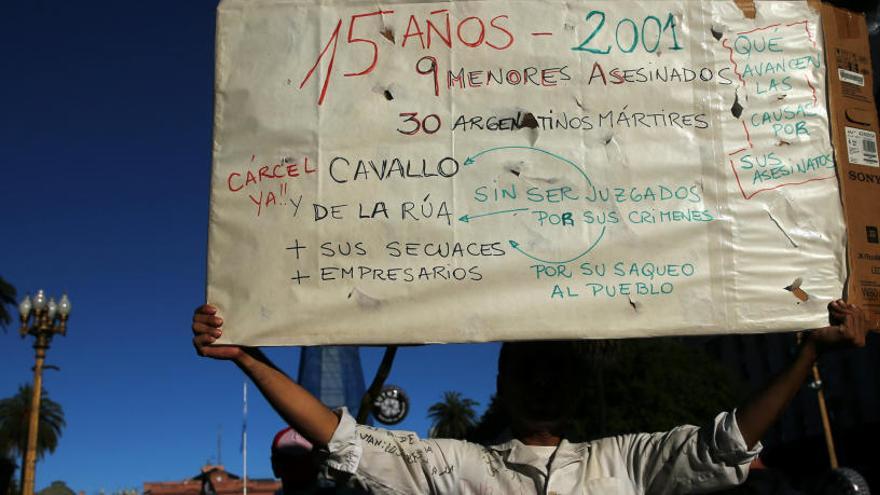 Un manifestante sostiene una pancarta de repulsa contra el crimen.