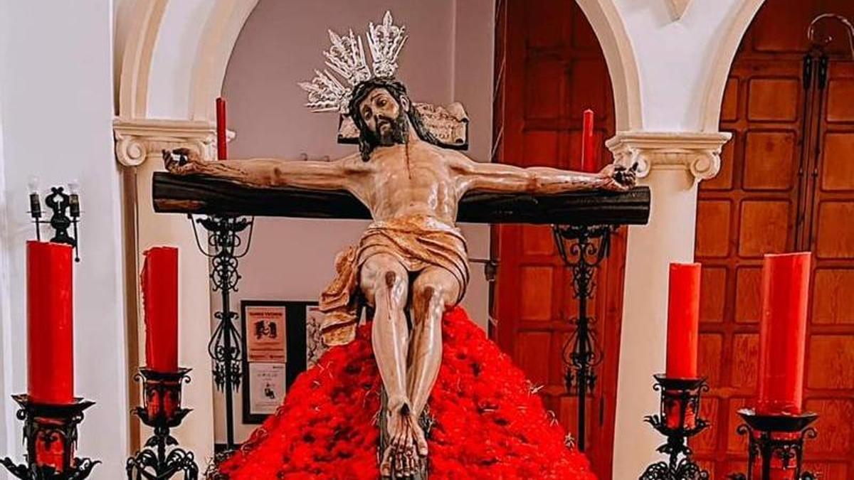 El Cristo de la Paz rodeado de claveles rojos y dispuesto para la procesión de este Viernes Santo.
