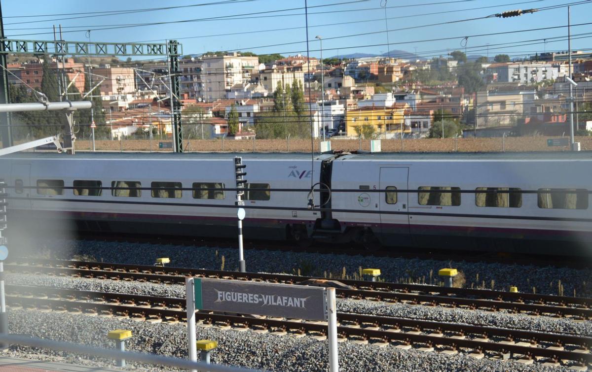 Un tren AVE aturat a l’estació de Figueres-Vilafant amb els barris del Culubret i Sant Joan al fons. | SANTI COLL