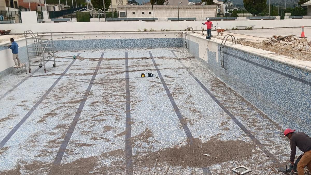 Varios de los trabajadores que participan en la reforma de la piscina de Vallada.