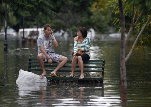 Vecinos sentados en un banco de un parque inundado en Buenos Aires