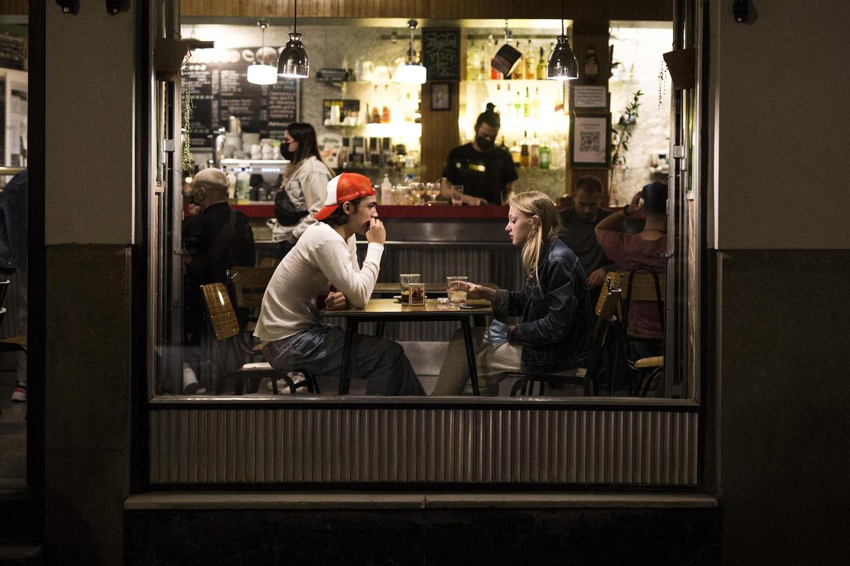 Dos jóvenes en el interior de un bar en el barrio de las Letras.