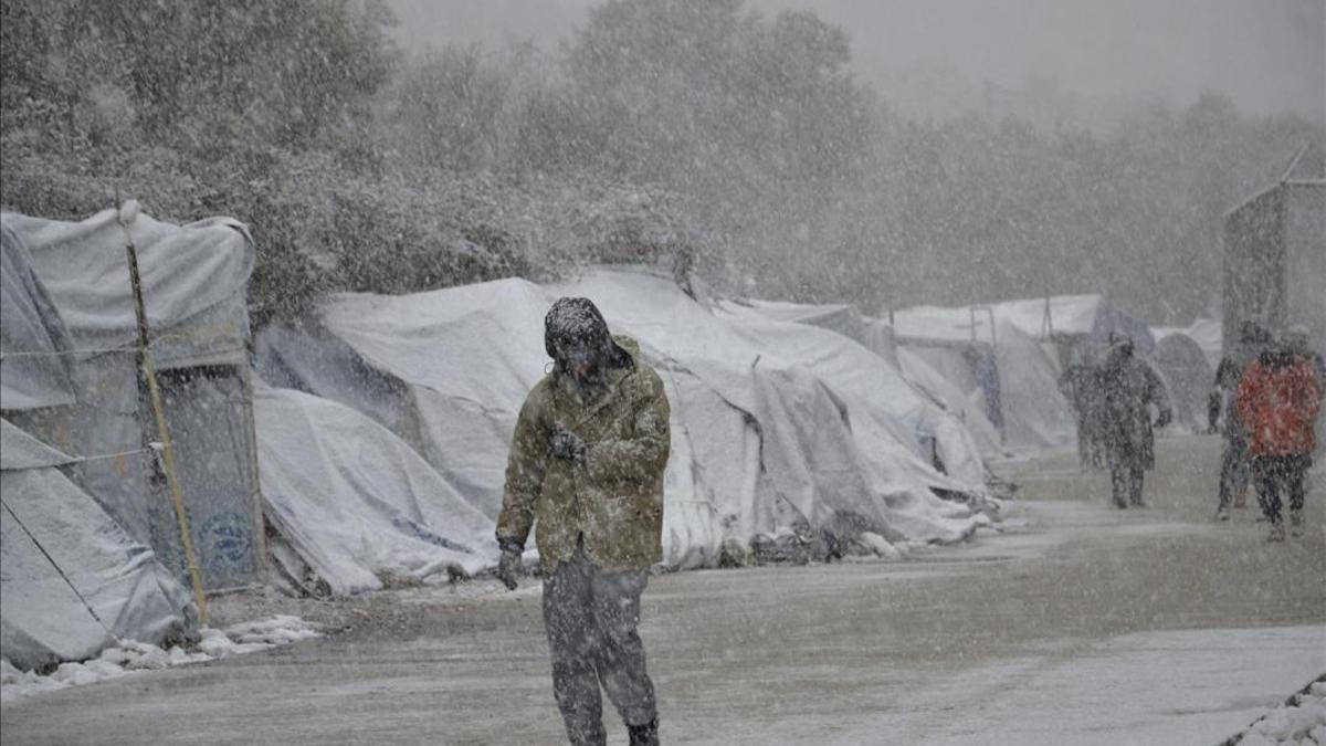 Varios refugiados caminan bajo la nieve en el campamento de refugiados de Moria en la isla de Lesbos, Grecia.