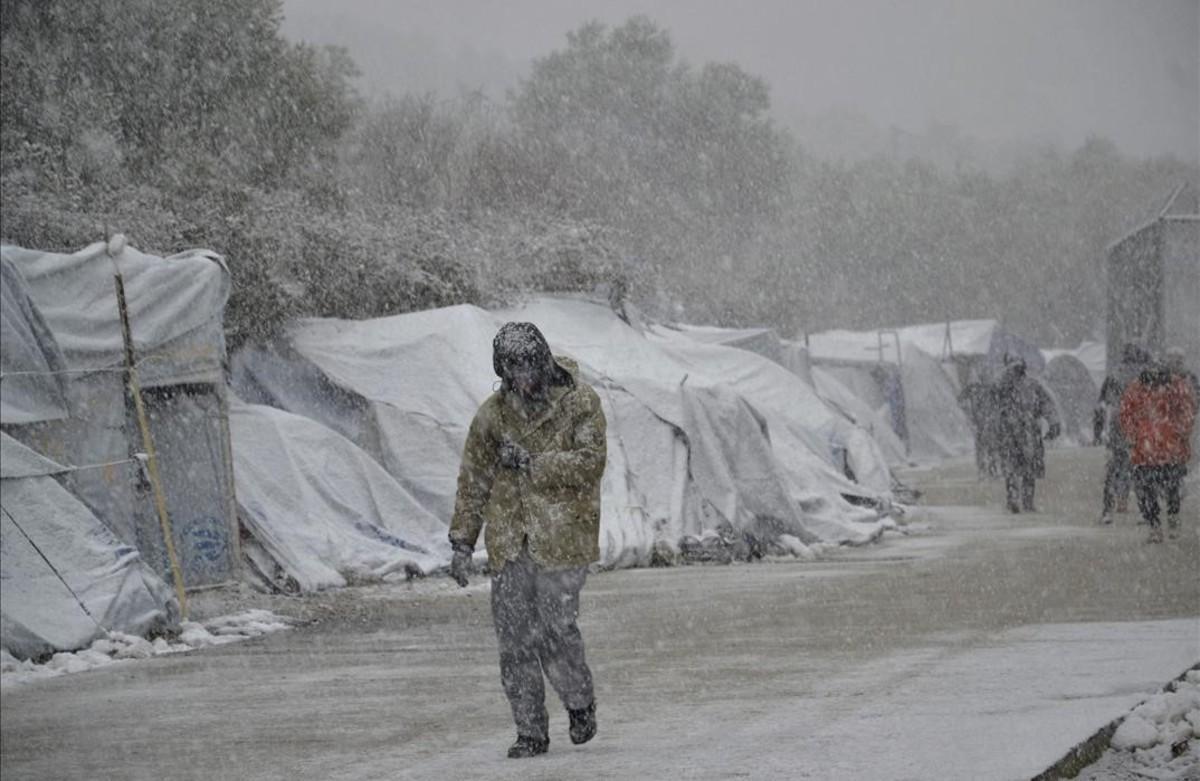 Diversos refugiats caminen sota la neu, al campament de refugiats de Moria, a l’illa de Lesbos (Grècia).