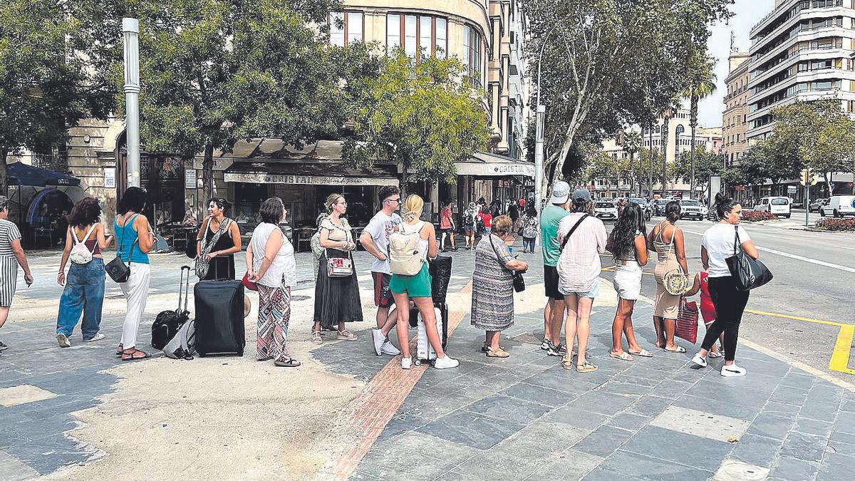 Cola de gente esperando un taxi en Plaza España de Palma.