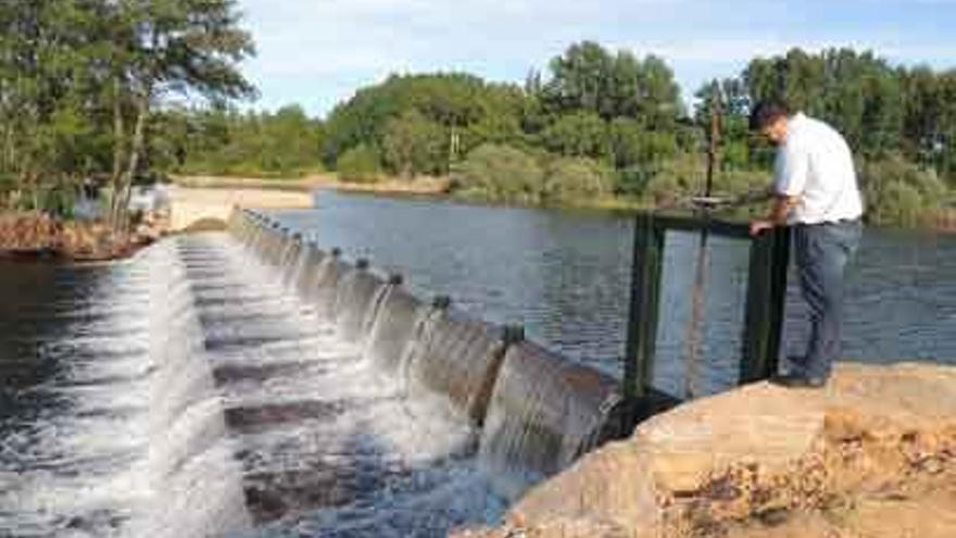 Un vecino observa la compuerta de la presa móvil instalada sobre el río Tera en Camarzana.