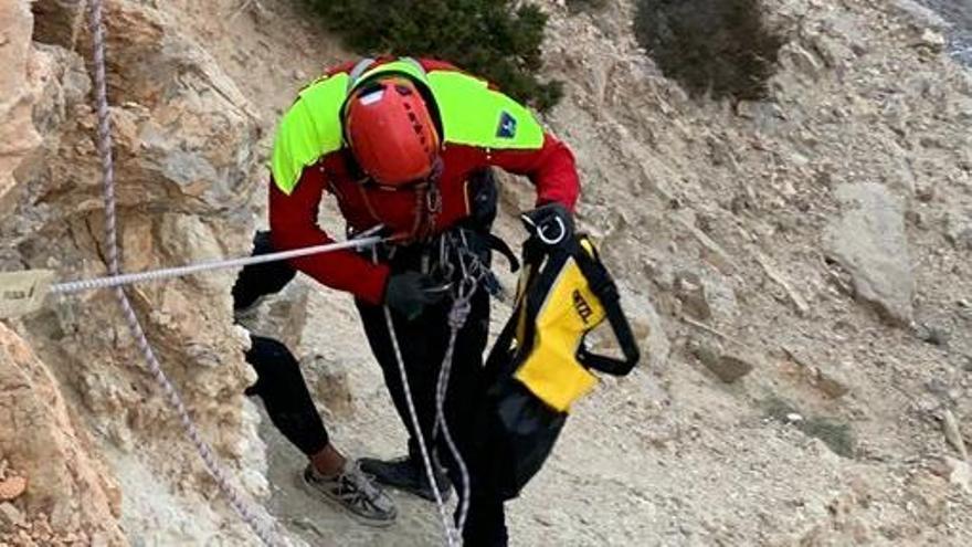 Uno de los bomberos ayuda al joven en el acantilado