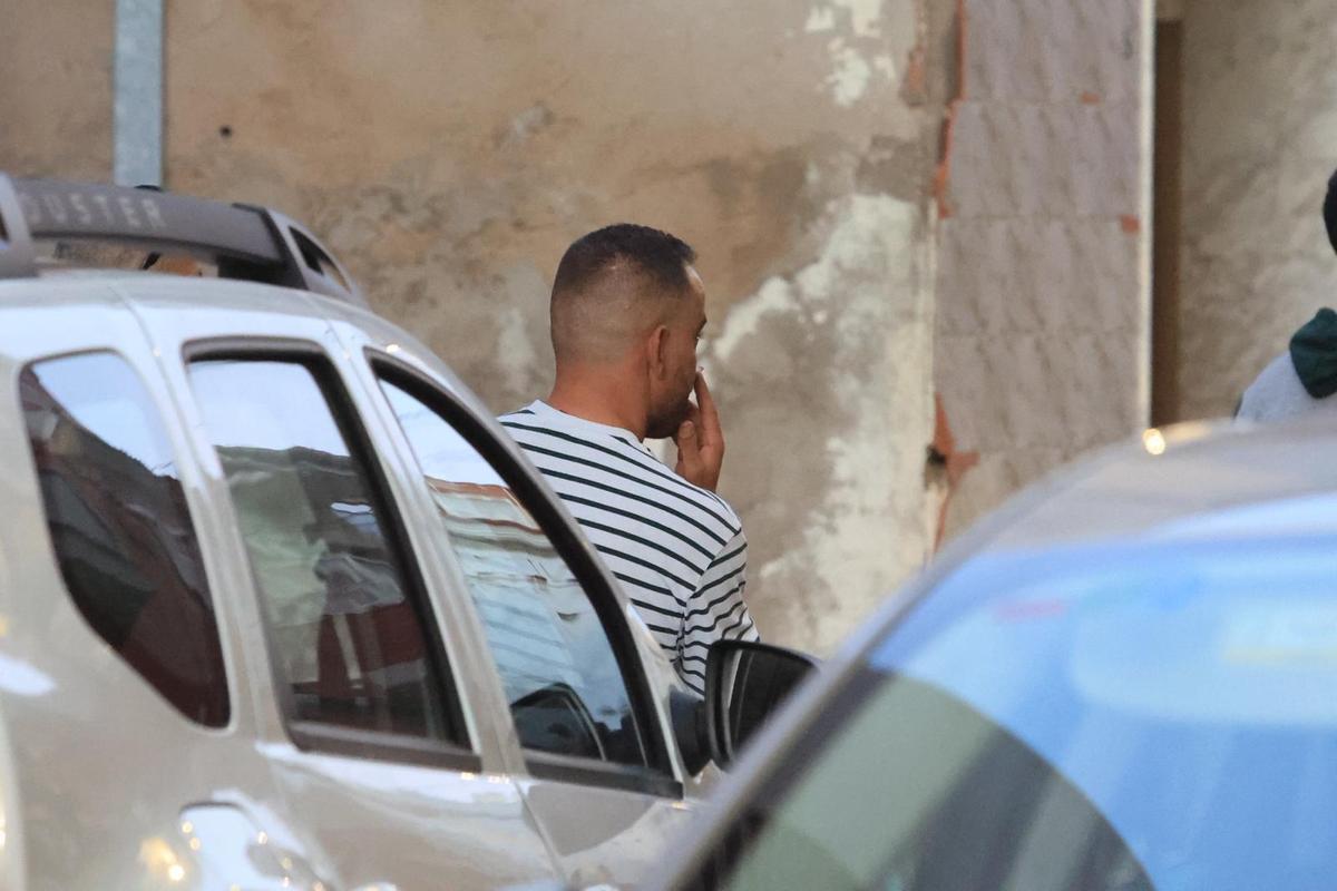 Un plano de espaldas del hombre, que estaba apoyado en un coche.