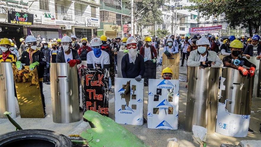 Los manifestantes birmanos con escudos improvisados.