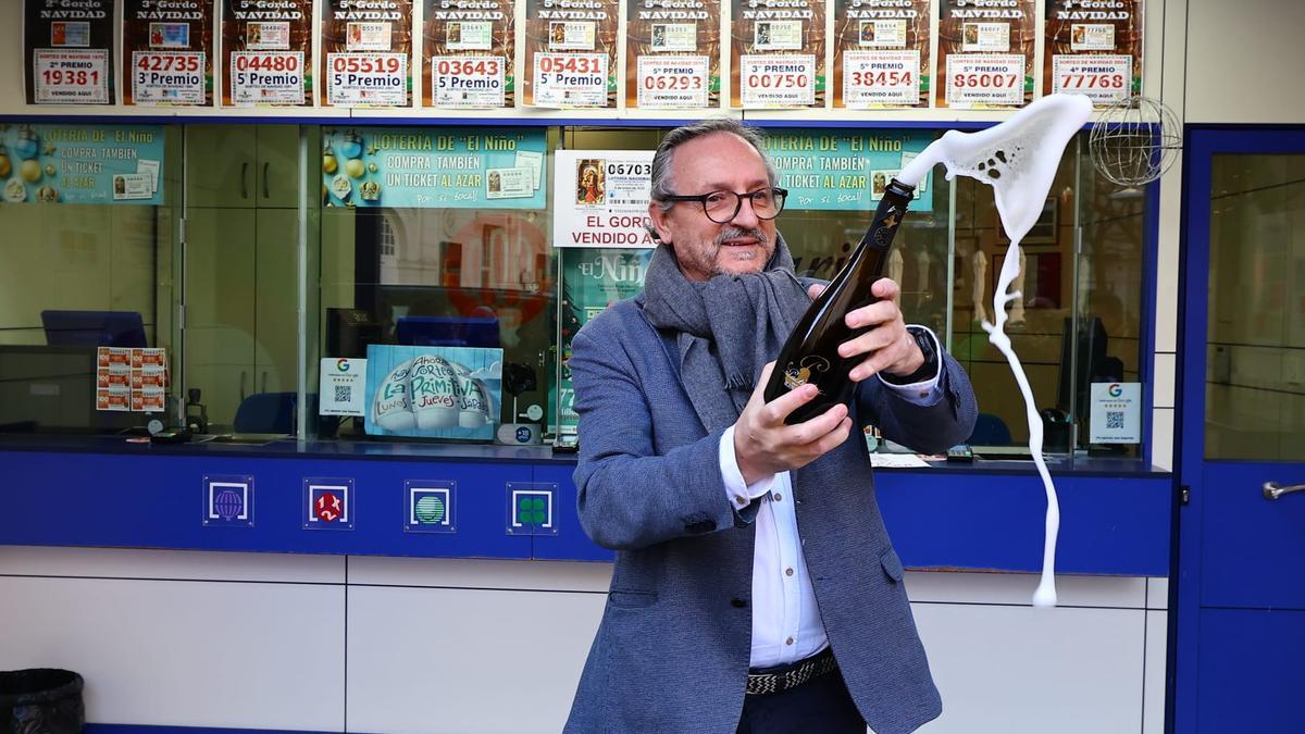 Alejandro Aznar, responsable de la administración de loteria El Rosario de Zaragoza, descorchando una botella de cava por el primer premio de la lotería del Niño.