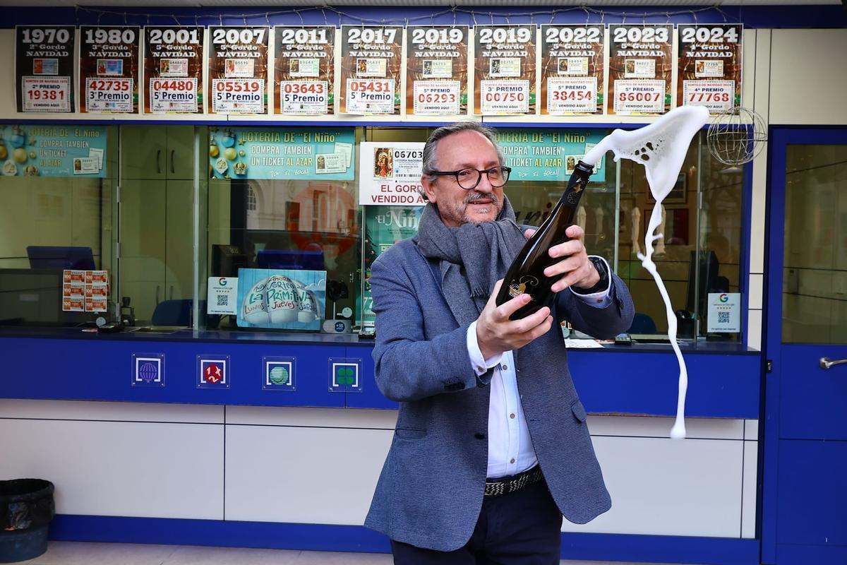 Alejandro Aznar, responsable de la administración de loteria El Rosario de Zaragoza, descorchando una botella de cava por el primer premio de la lotería del Niño.