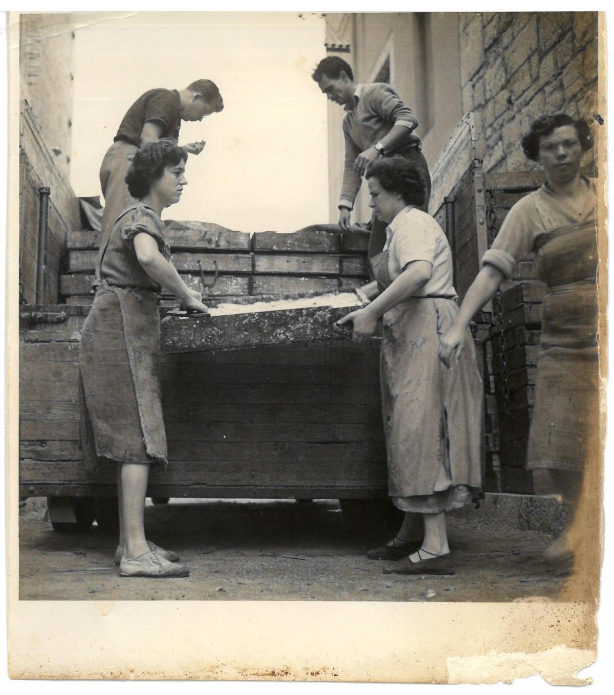 Carregant caixes de peix a la Fàbrica de salaons Solés, a la Platja, dècada de 1950. A l’esquerra, Lluïsa Sastre i Martí Solés Andreu. A la dreta, Enriqueta Rúbies, Marina Granollers i Narcís Graboleda “Romaguera”
