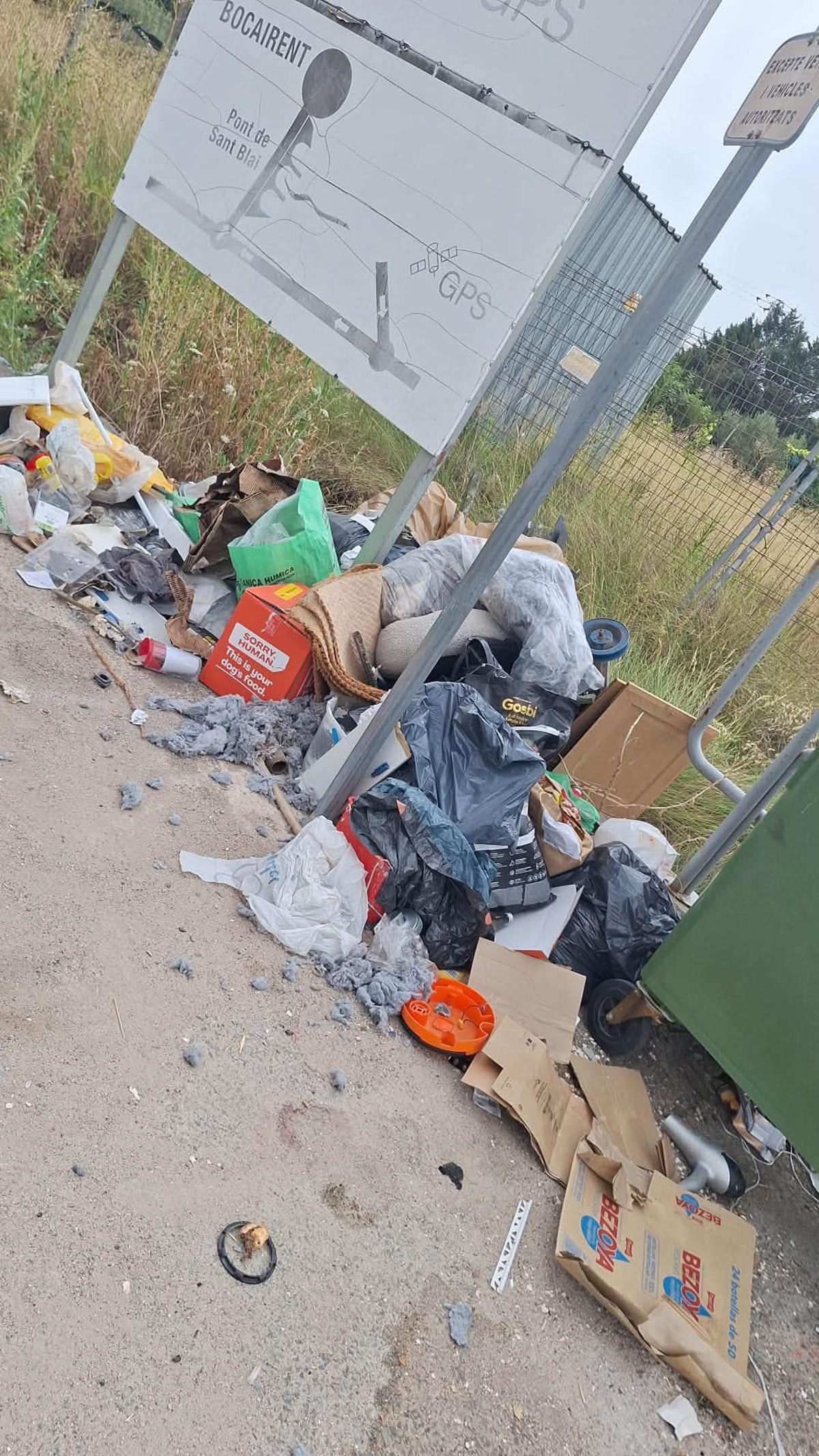 Acumulación de residuos, trastos y enseres junto a unos contenedores en una zona diseminada de Bocairent.