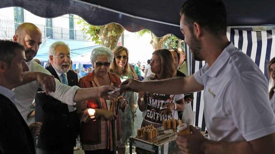 Las autoridades asistentes a la inauguración, catando miel en uno de los puestos de la Feira. // Jesús Regal