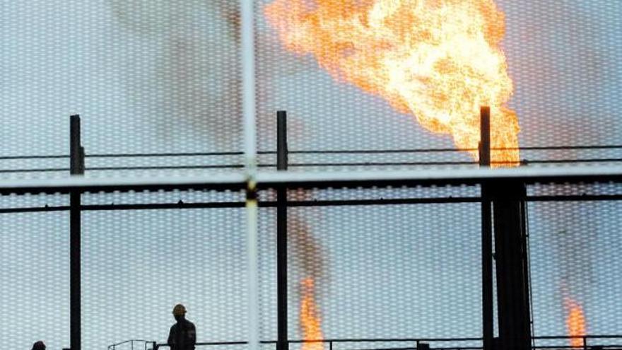 Trabajadores de la coquería, ante los mecheros de gas encendidos.