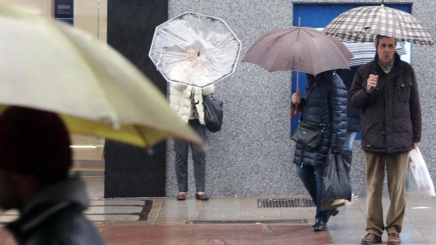 Gente protegiéndose de la lluvia y el viento. // Marta G. Brea