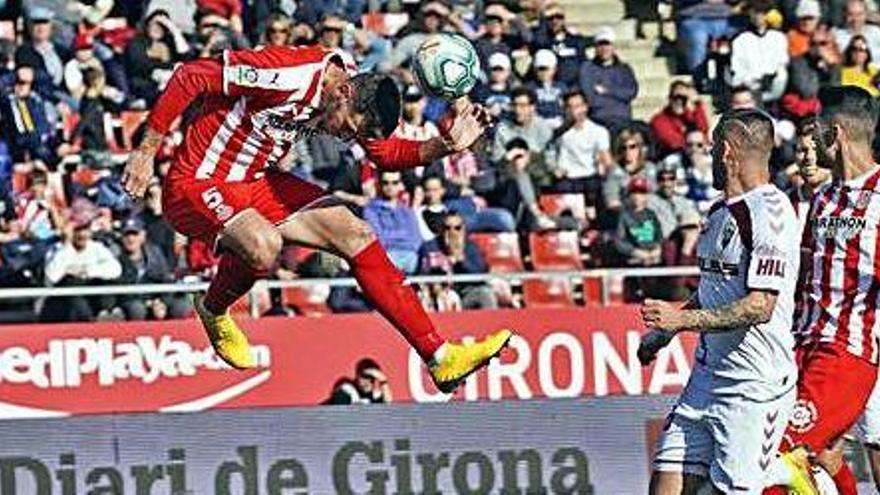 Pedro Alcalá refusa de cap una pilota davant la presència de Javi Acuña.