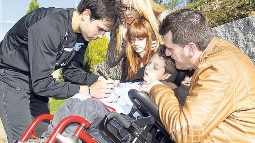 Oubiña firma la camiseta a Álex, en presencia de sus padres Vanesa y Aitor y su hermana Alma. // R. Grobas