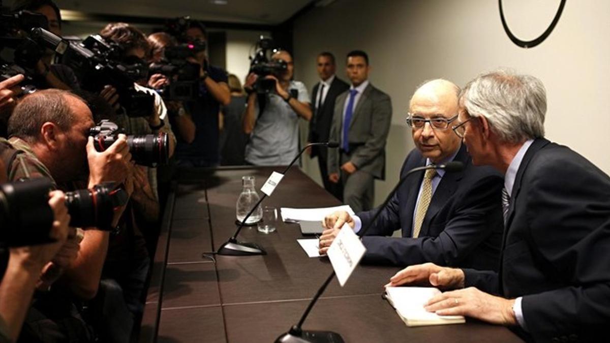 El ministro de Hacienda, Cristóbal Montoro, conversa con el presidente del Cercle de Economia, Antón Costas (derecha), momentos antes de su intervención en un coloquio, este martes, 22 de julio, en Barcelona.