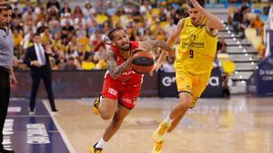 El jugador del Basquet Girona Jeremiah Hill bota el balón perseguido por Brussino. 