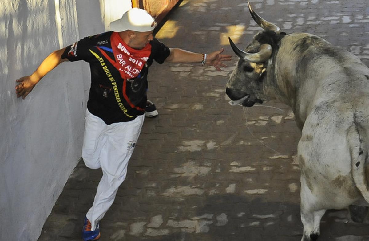 Un corredor escapa d’un toro a l’entrada de la plaça.