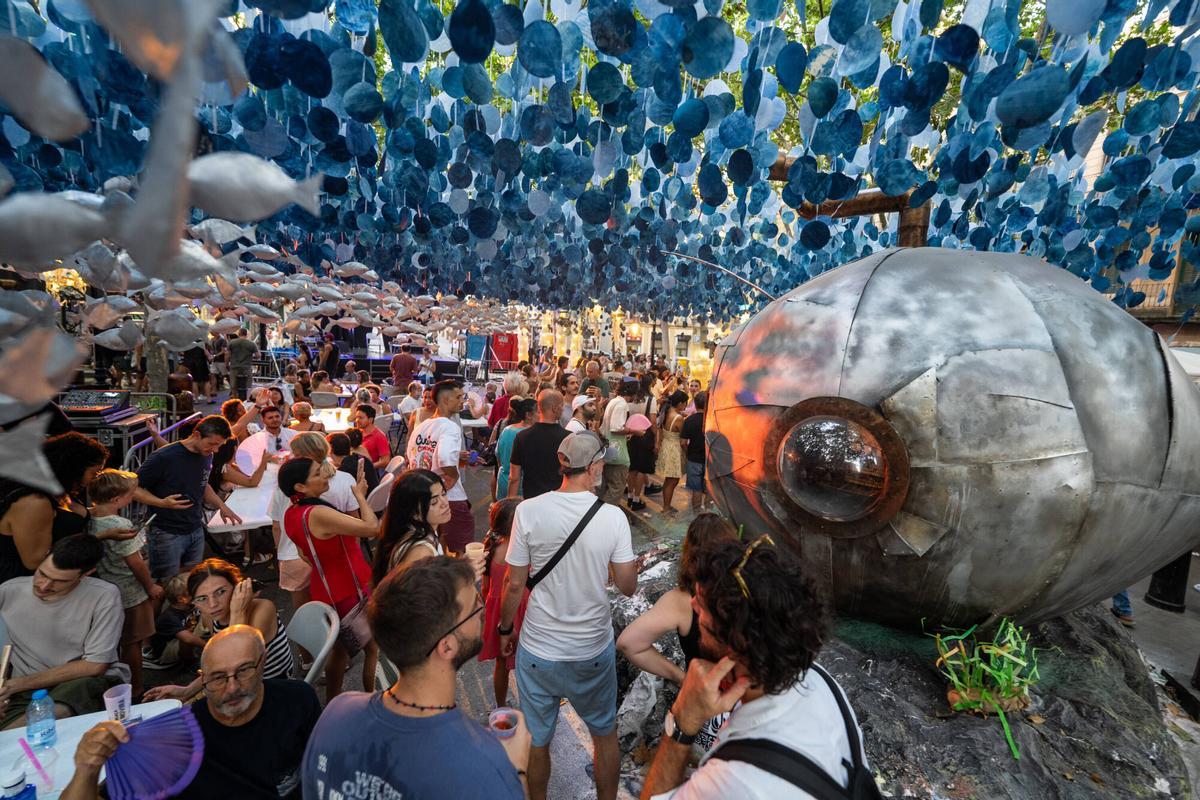 Barcelona. Vecinos y visitantes recorren la plaza Rovira y fotografían la decoración de la calle ganadora de la Festa Major de Gràcia, antes de la llegada de una mayor afluencia de público. 19 de agosto de 2026. Sociedad. AUTOR: ZOWY VOETEN