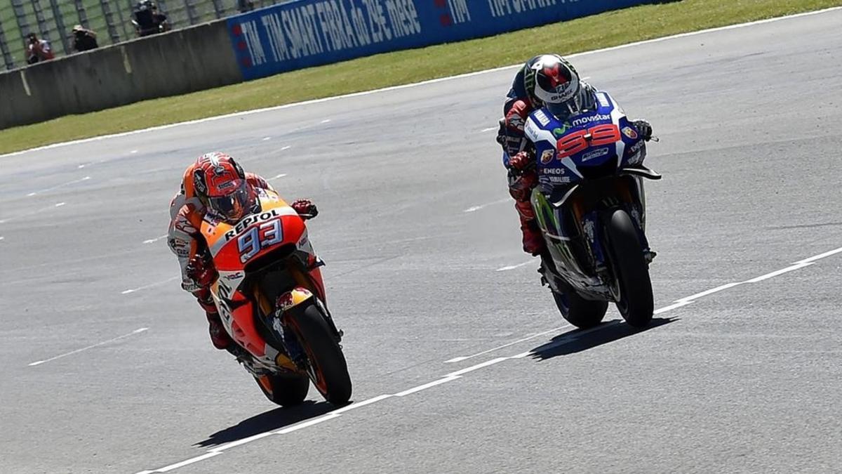 Jorge Lorenzo, a la derecha, rebasa en la misma línea de meta a Marc Márquez en la carrera de Moto GP del circuito de Mugello