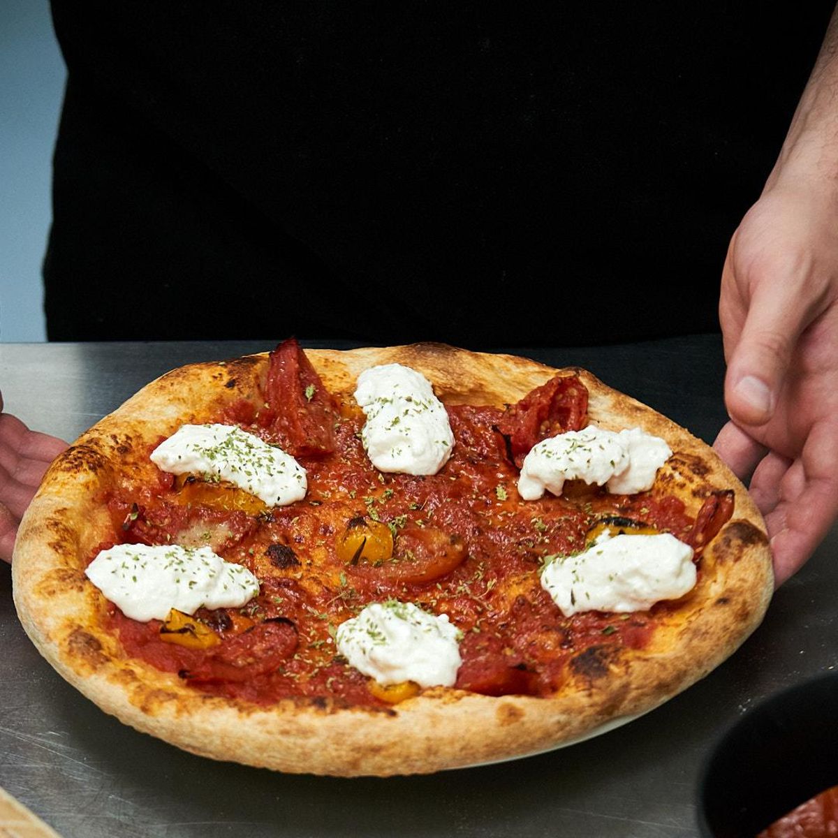 Un cocinero con una pizza.