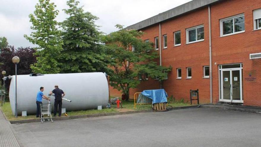 Operarios instalando un depósito provisional en el hospital.