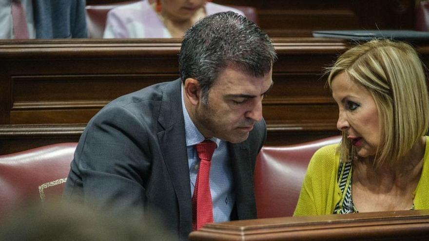 Manuel Domínguez, presidente del PP canario, charla con Australia Navarro en el pleno del Parlamento regional.