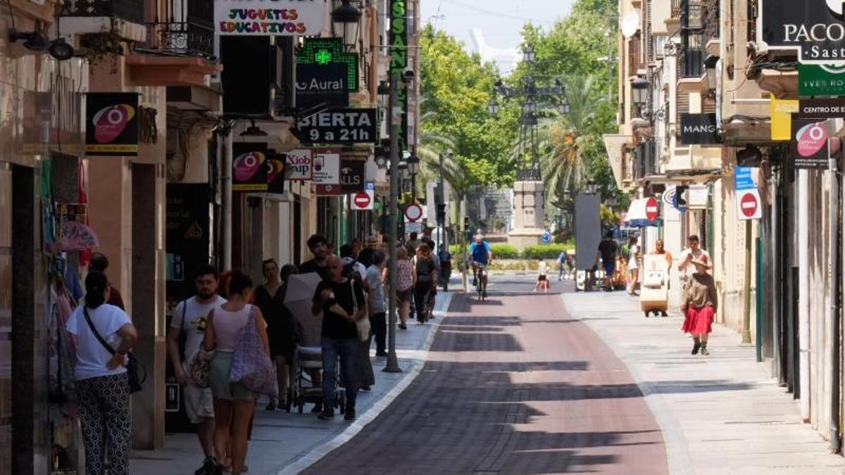 Castellonenses caminan por la sombra en la calle Zaragoza, con la Farola de fondo, mientras casi nadie va por el lado del sol por el calor.