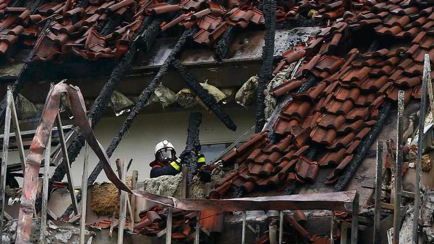 Un bombero inspecciona los restos del incendio.