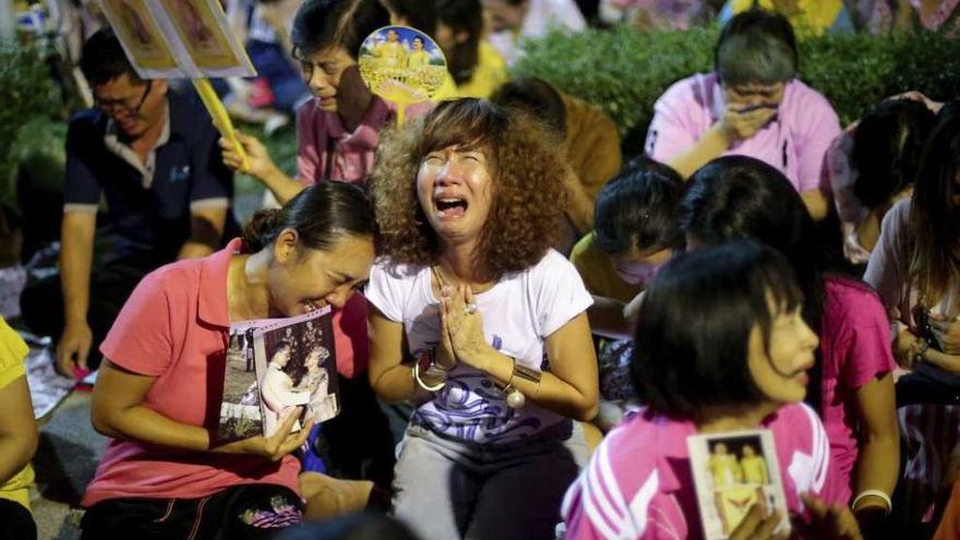 Decenas de tailandeses se concentraron frente al hospital para rezar por el rey fallecido.