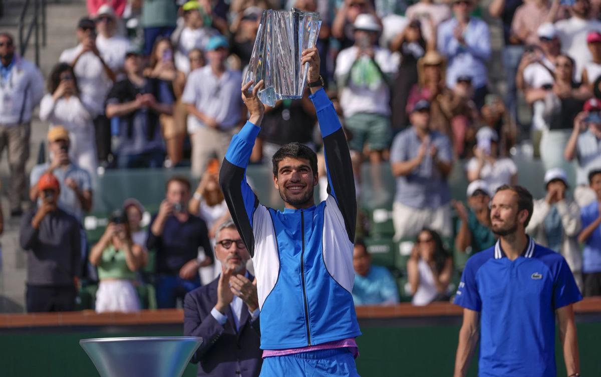 Carlos Alcaraz levanta el trofeo ante la mirada de Daniil Medvedev. | RYAN SUN/AP