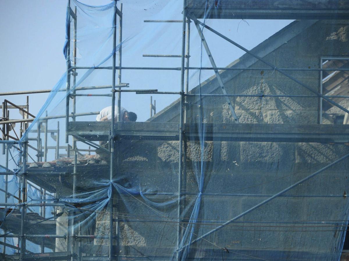 Un trabajador, ayer, en una obra en la fachada de una casa de la comarca. | GONZALO NÚÑEZ