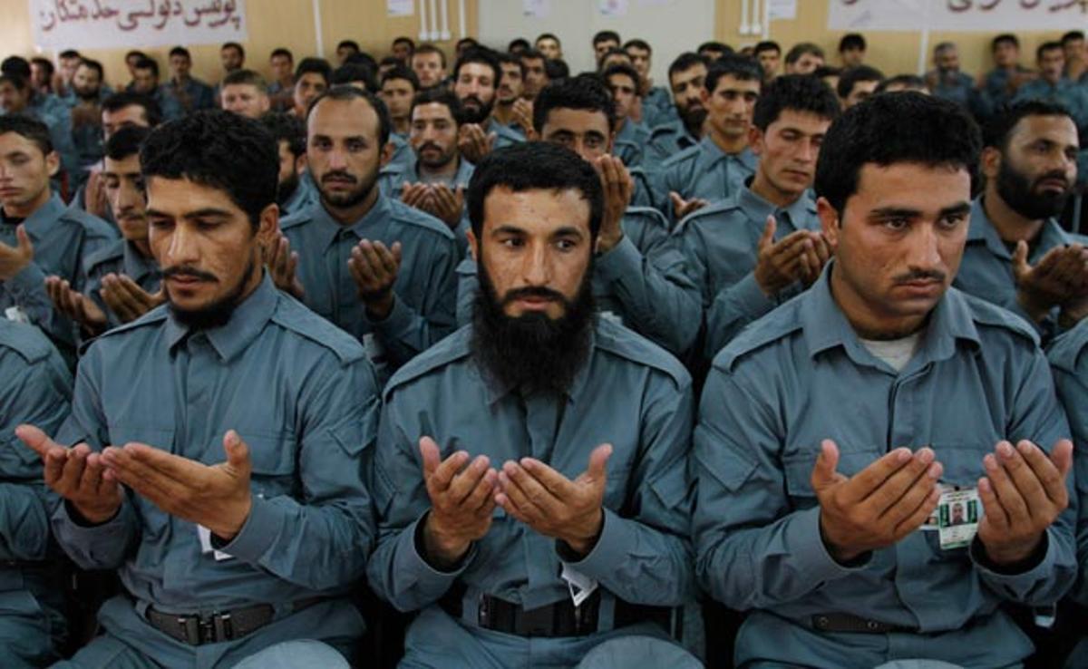 Oficials acabats de graduar de la policia afganesa resen durant la seva graduació a Kabul, l’Afganistan.