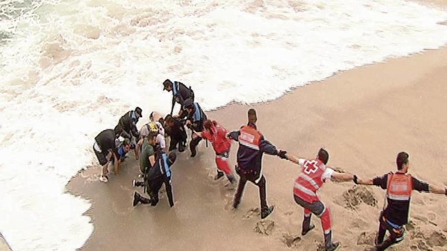 Cadena humana formada para salvar al policía que entró en el mar para rescatar al joven bañista.