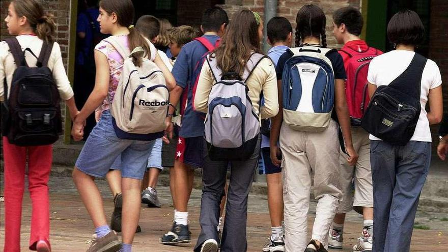 Alumnos con mochilas a las puertas de un instituto.