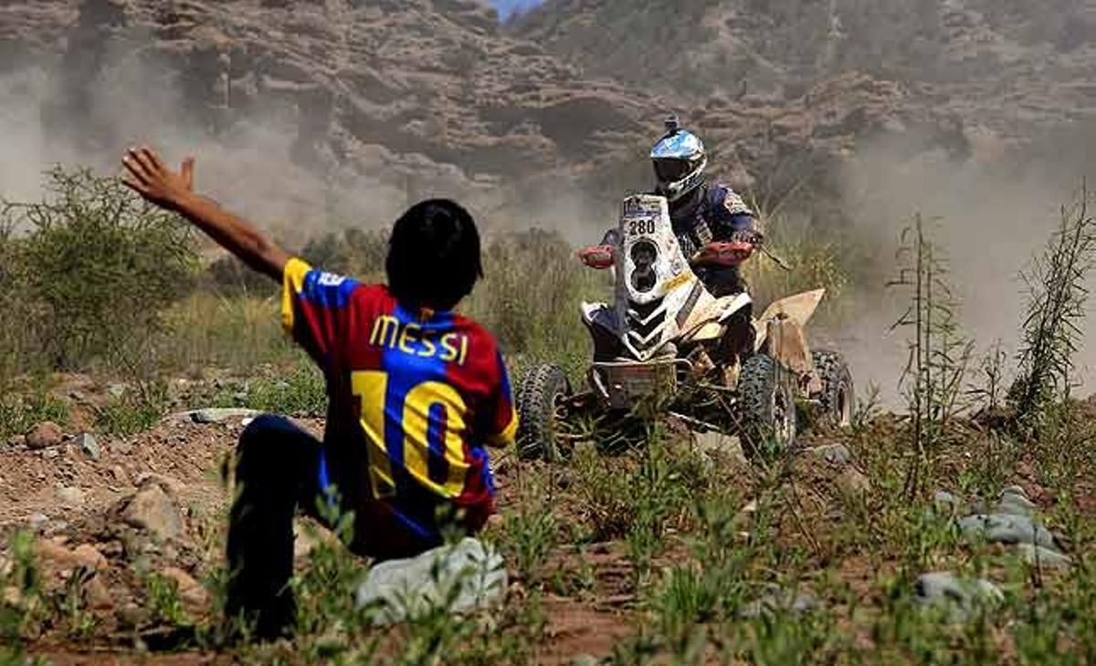 Un espectador vestit amb una samarreta del Barça amb el nom de Lionel Messi anima un corredor del Ral·li Dakar Argentina-Xile, entre Chilecito i San Juan (Argentina).
