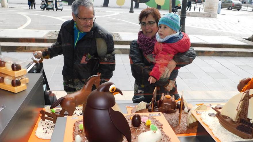 Compradors observant una mona de Pasqua en un aparador al centre de Manresa.