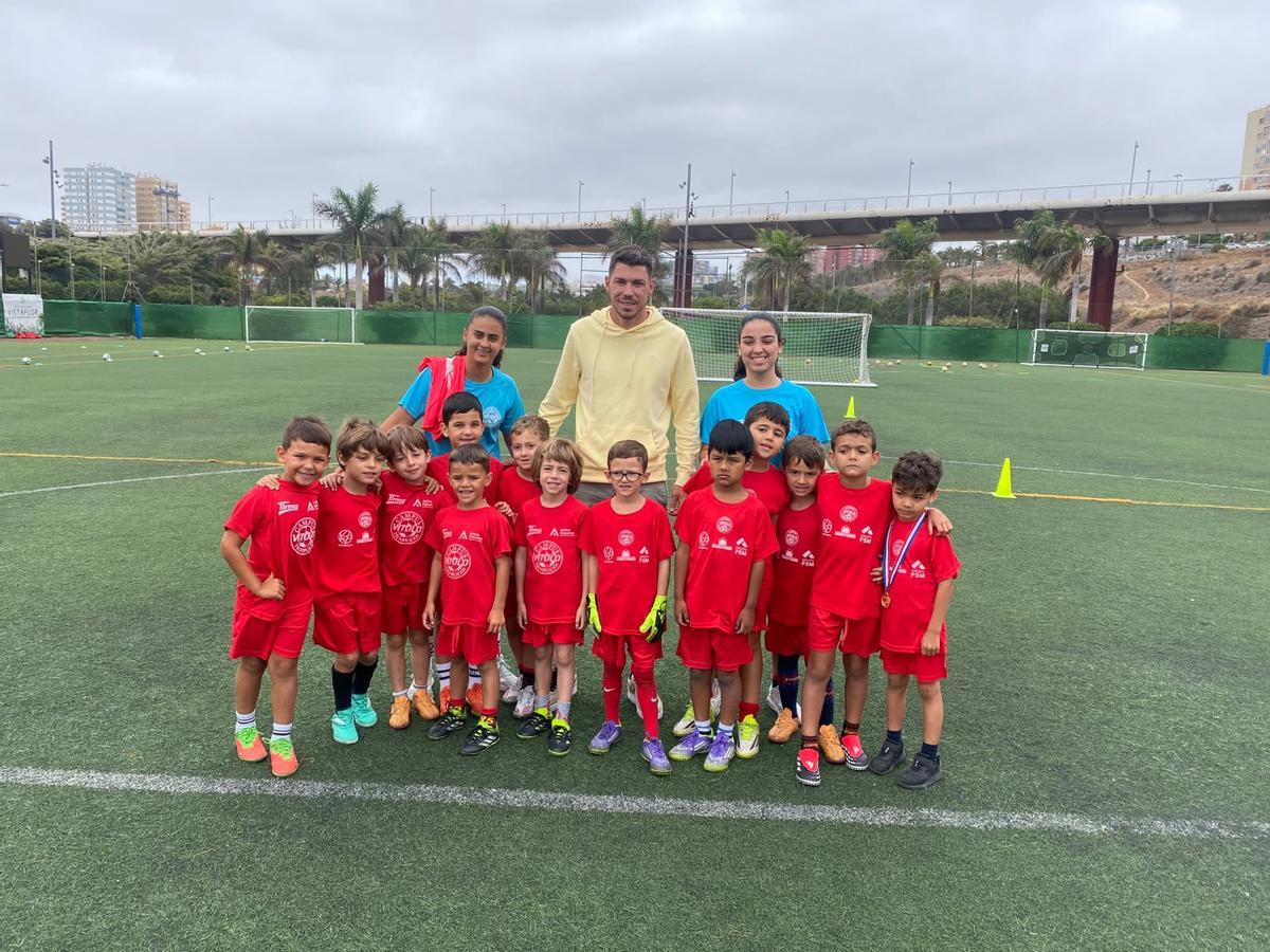 Raúl Lizoain posa con los más peques del Campus Vitolo durante su visita.
