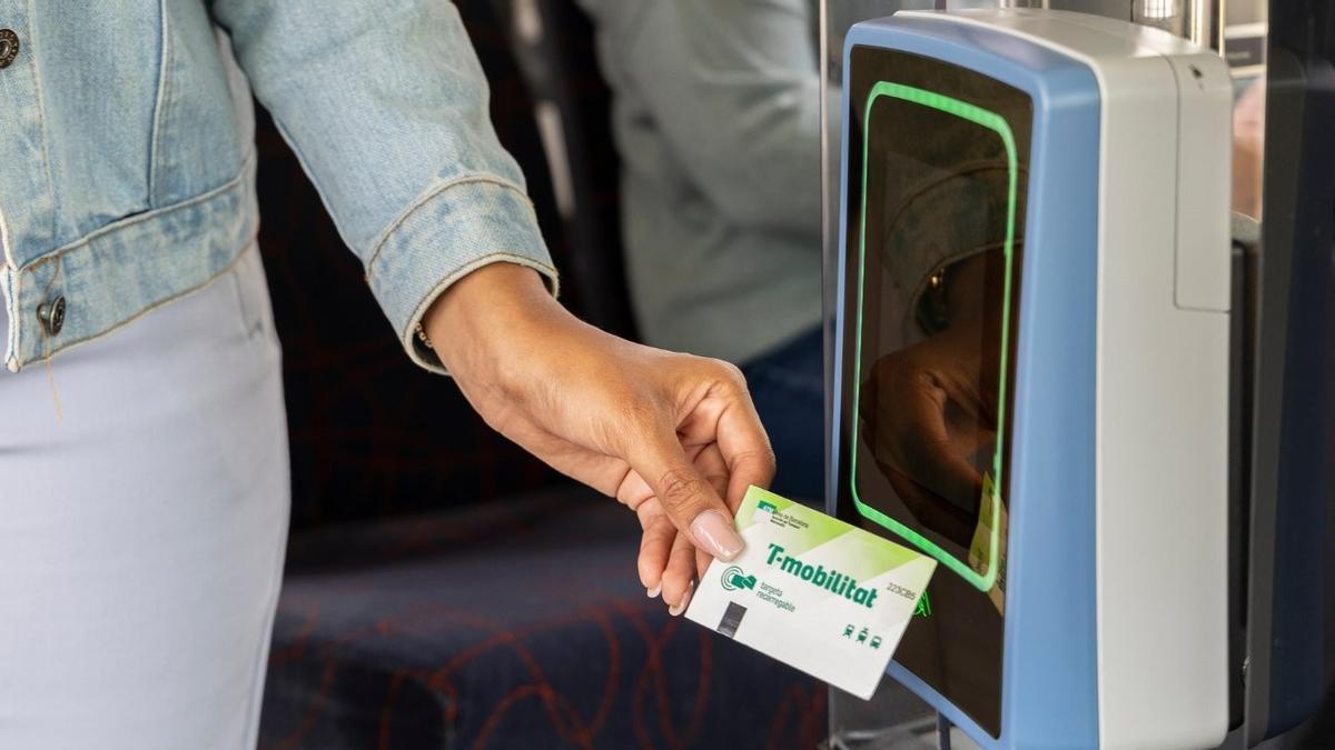 Una usuaria valida una T-Mobilitat de cartón al subir a un autobús