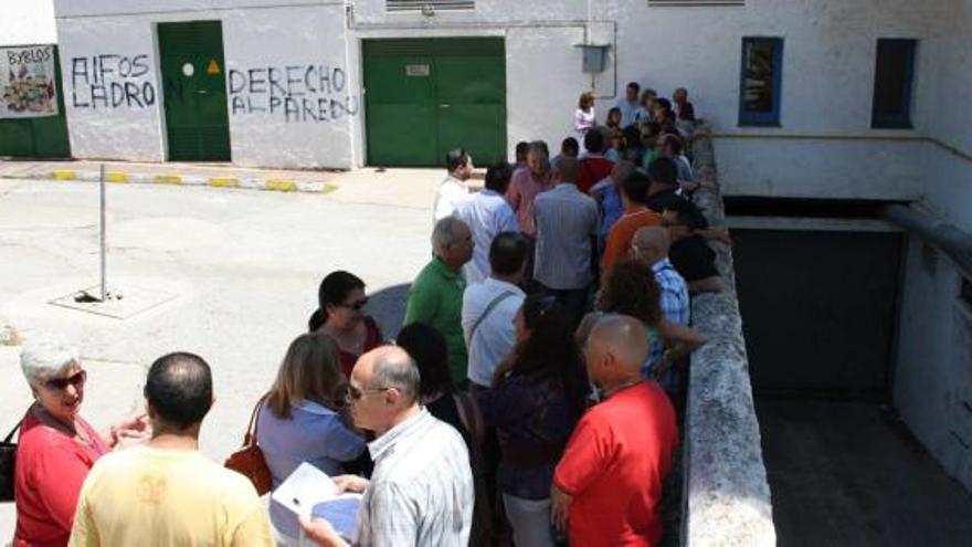 Algunos de los 134 trabajadores aguardan en fila su momento pare recoger los documentos que les permitirán cobrar el paro.