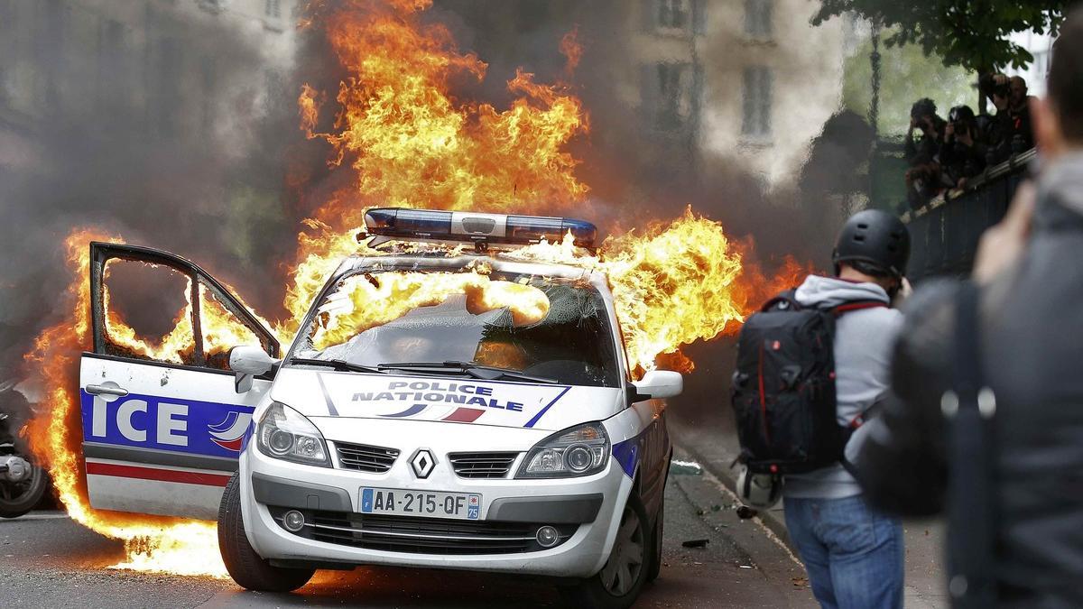 A police car burns during a demonstration against police violence and against French labour law reform in Paris