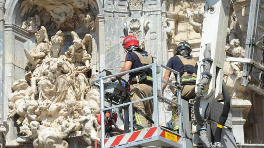 Los bomberos retiran una plancha de plomo de la fachada de la Catedral de Murcia.