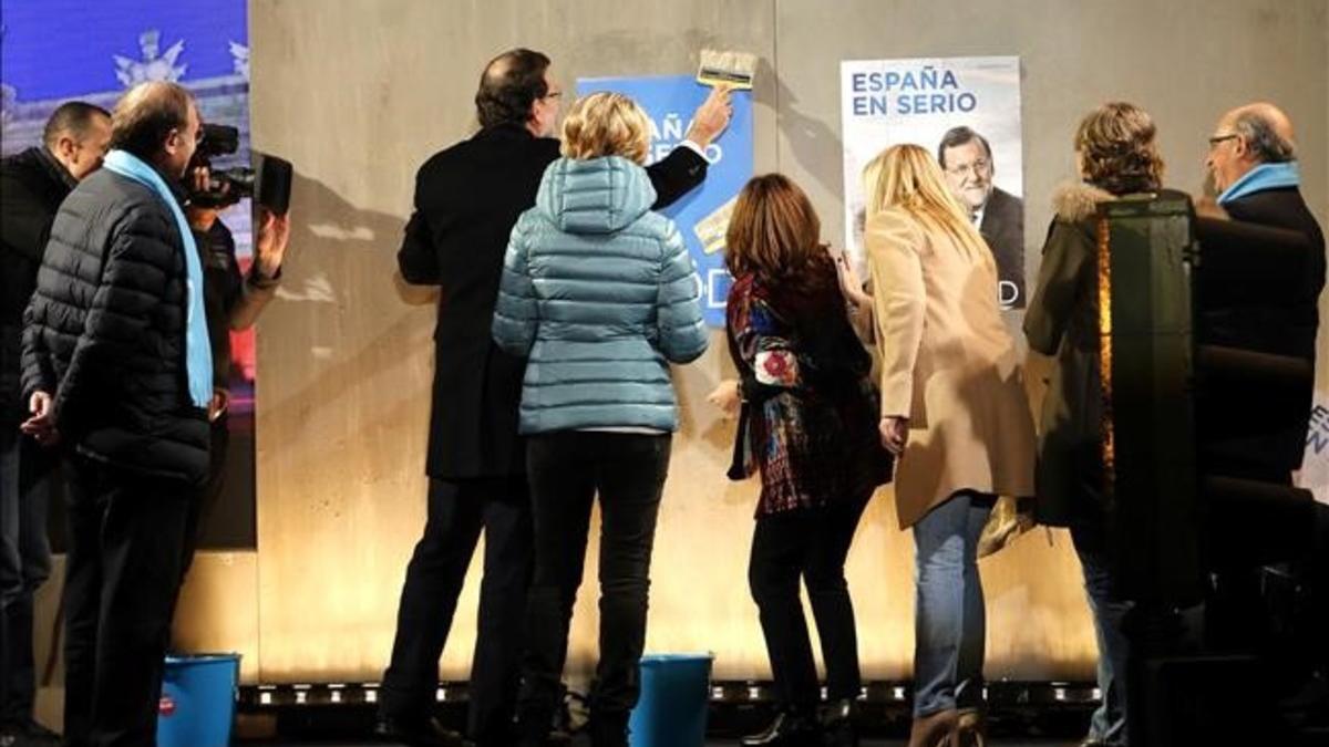 Rajoy comienza la campaña electoral con la pegada de carteles en la sede del PP