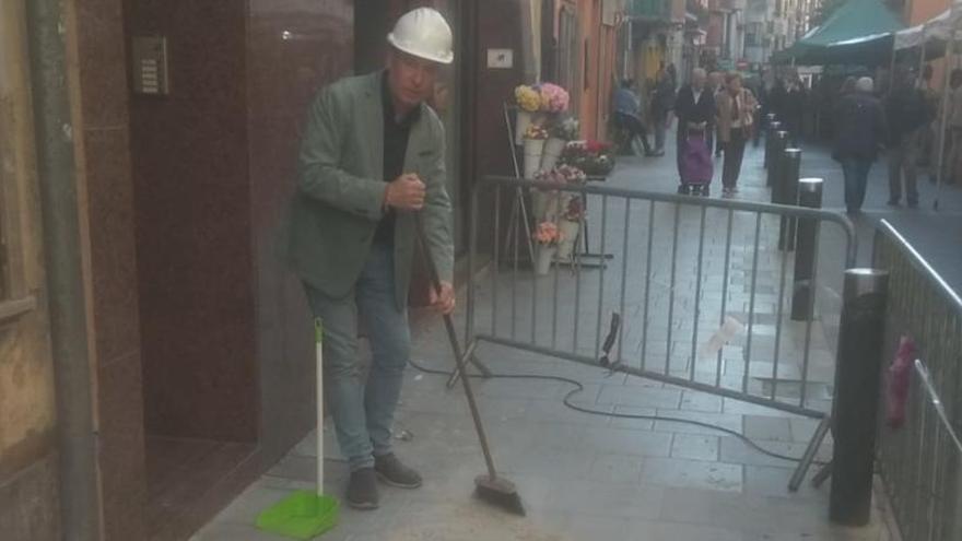 Juan Carlos Soses, president dels botiguers de la Seu netejant la runa d&#039;un tros de carrer Major